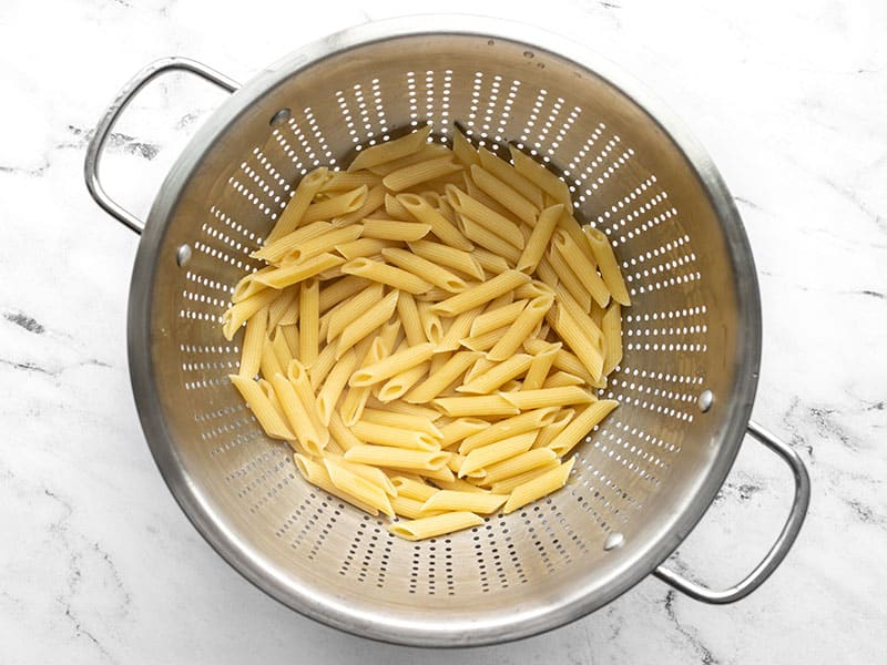 Cooked pasta in a metal colander