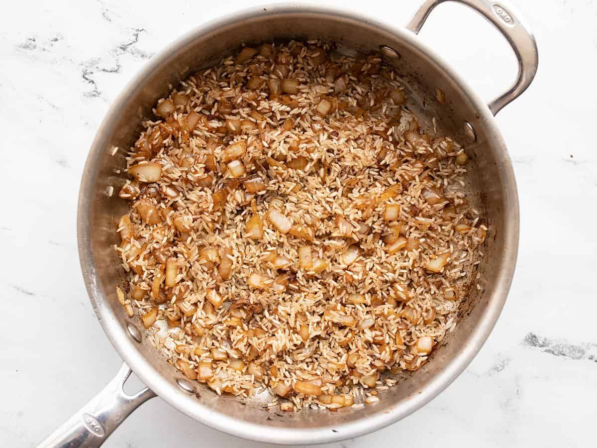 Rice added to the skillet with the onion.