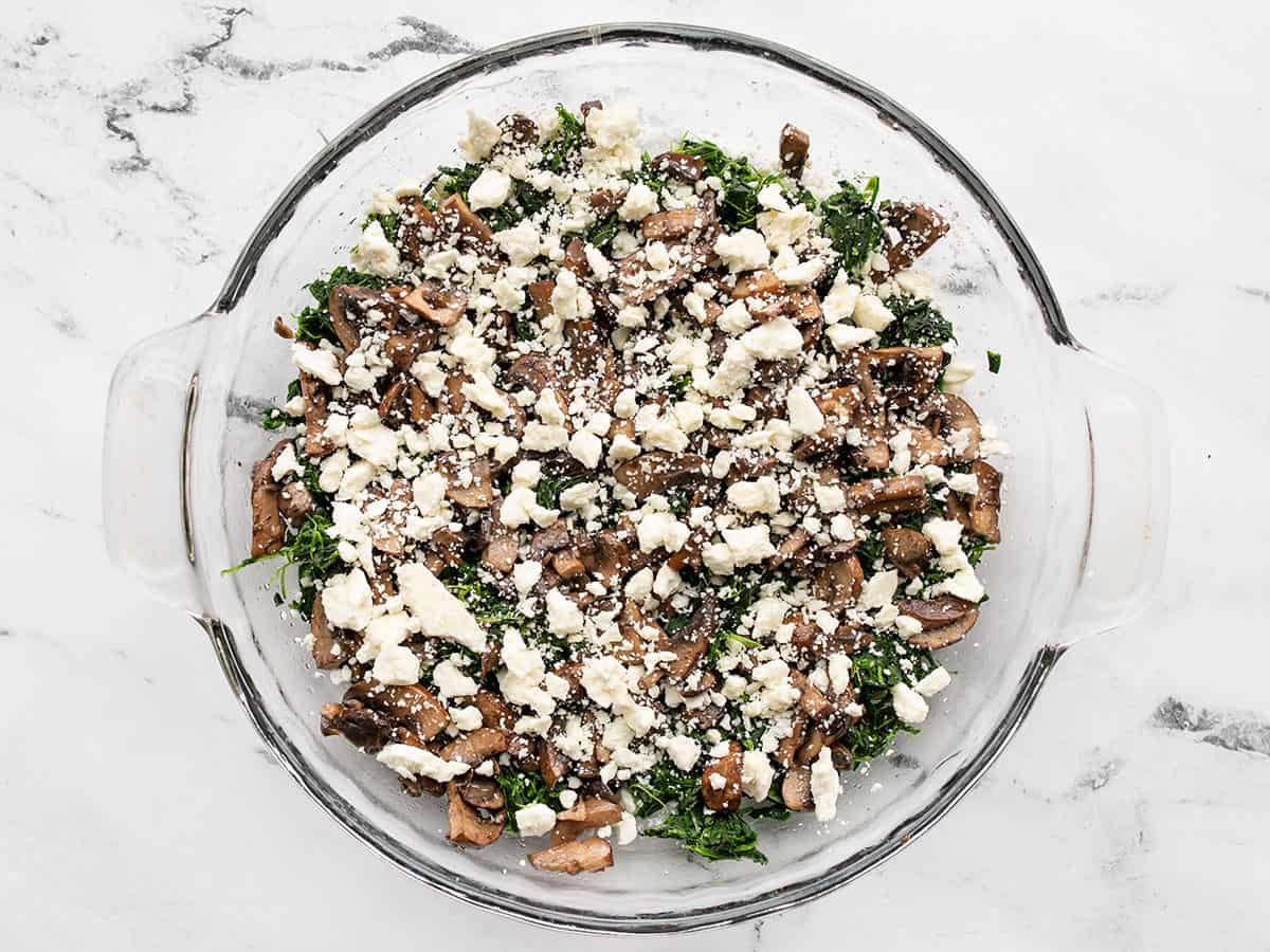 Layered mushrooms, spinach, and feta in a pie dish