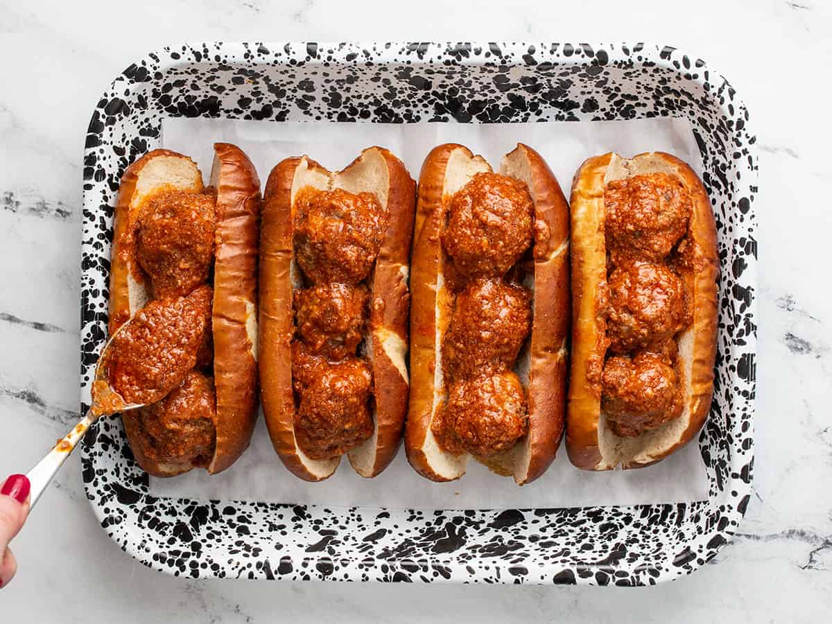 Meatballs in subs in a baking dish.