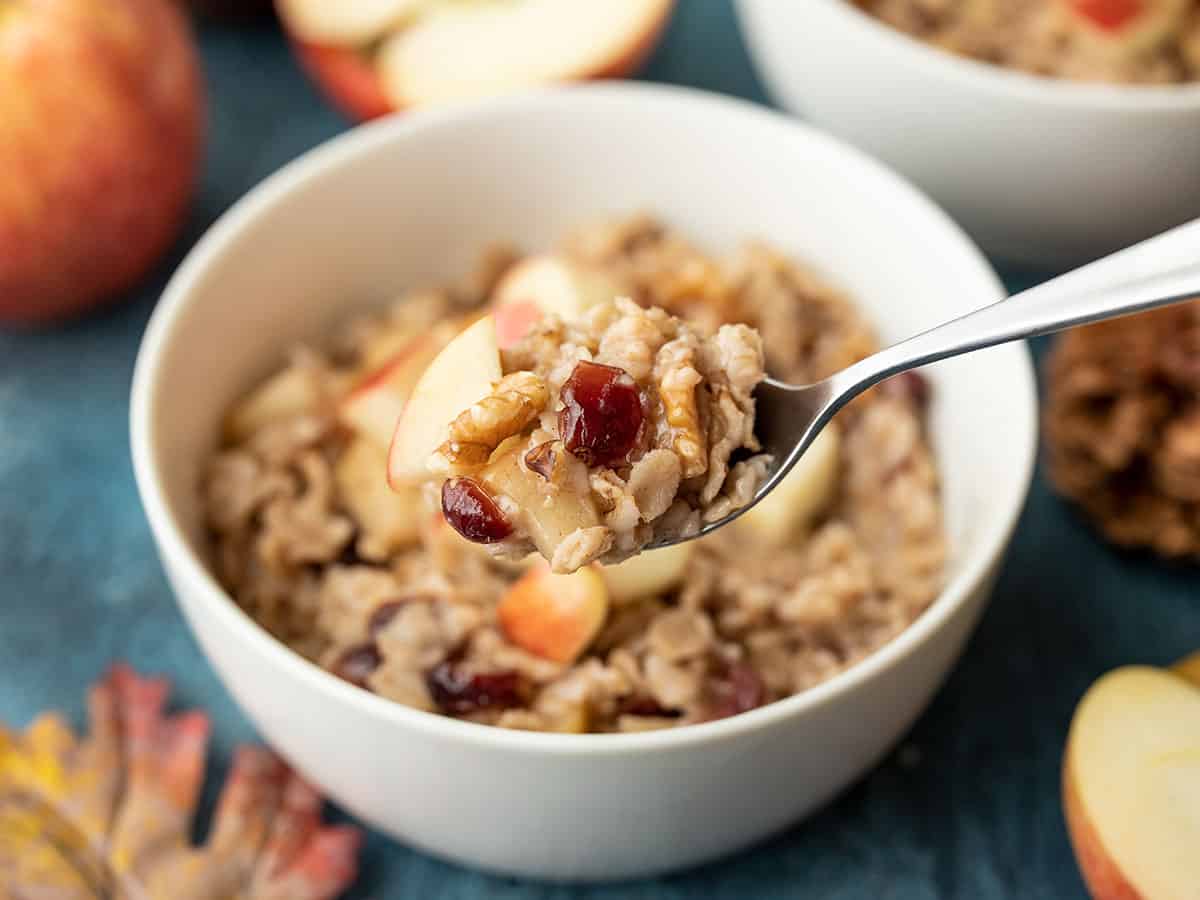A spoonful of autumn fruit and nut oatmeal held above the bowl