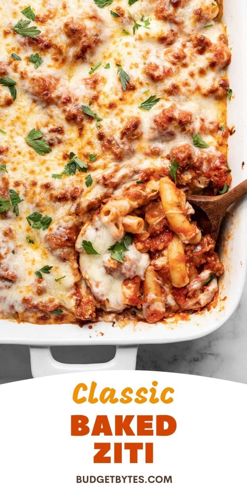 Close up overhead view of baked ziti being scooped from dish, title text at the bottom