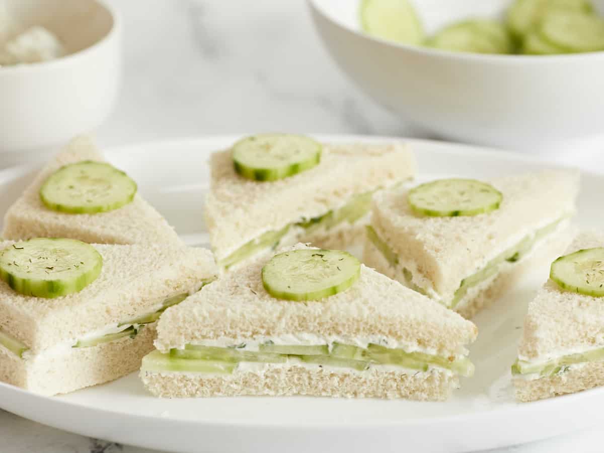 Side view of cucumber sandwiches on a platter.