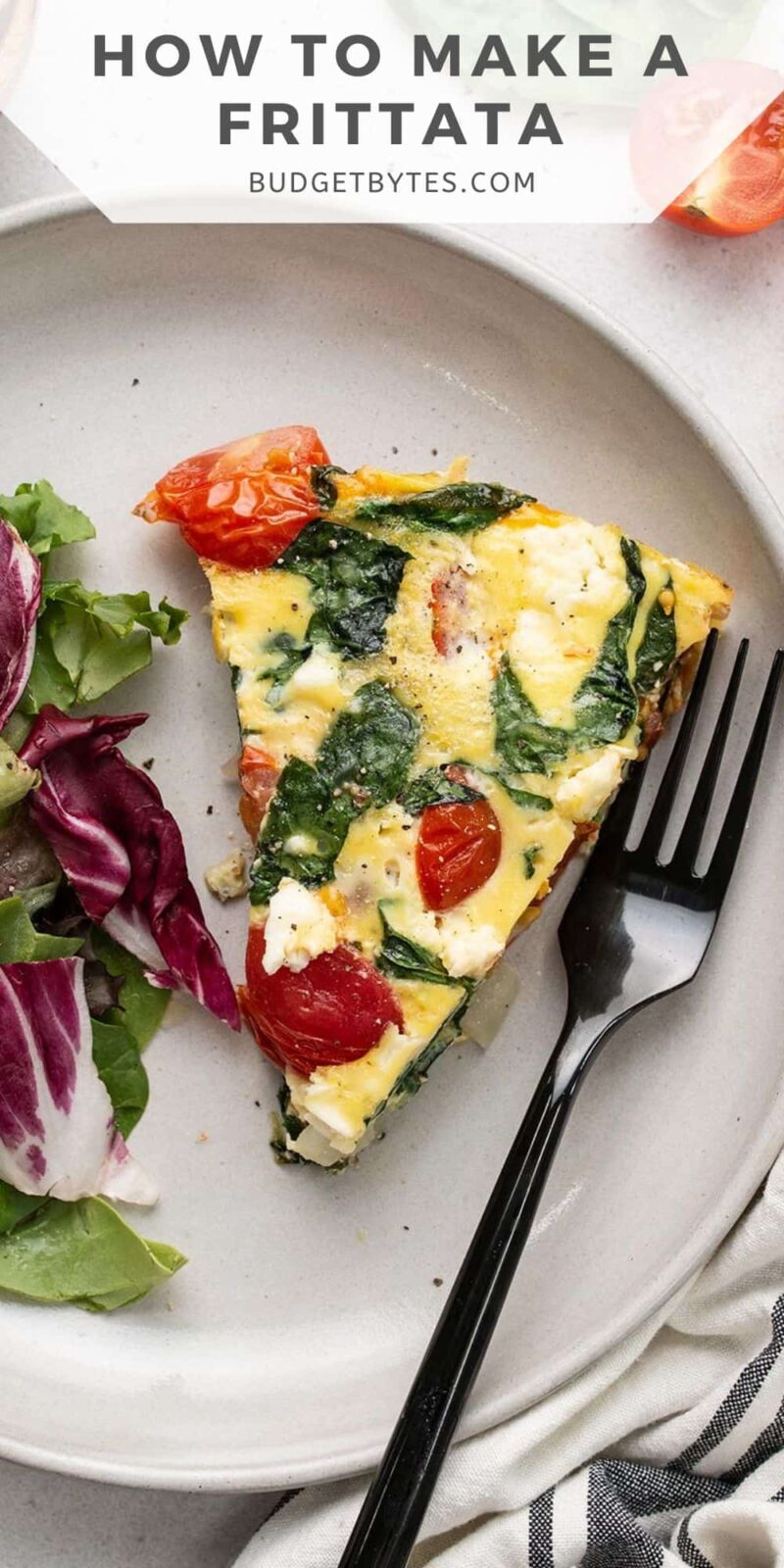 A slice of frittata on a plate with salad.