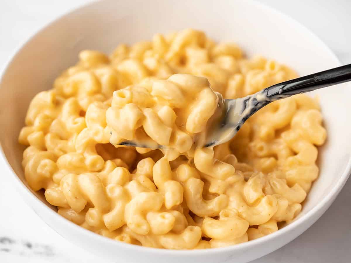 side view of macaroni and cheese in a bowl with a fork