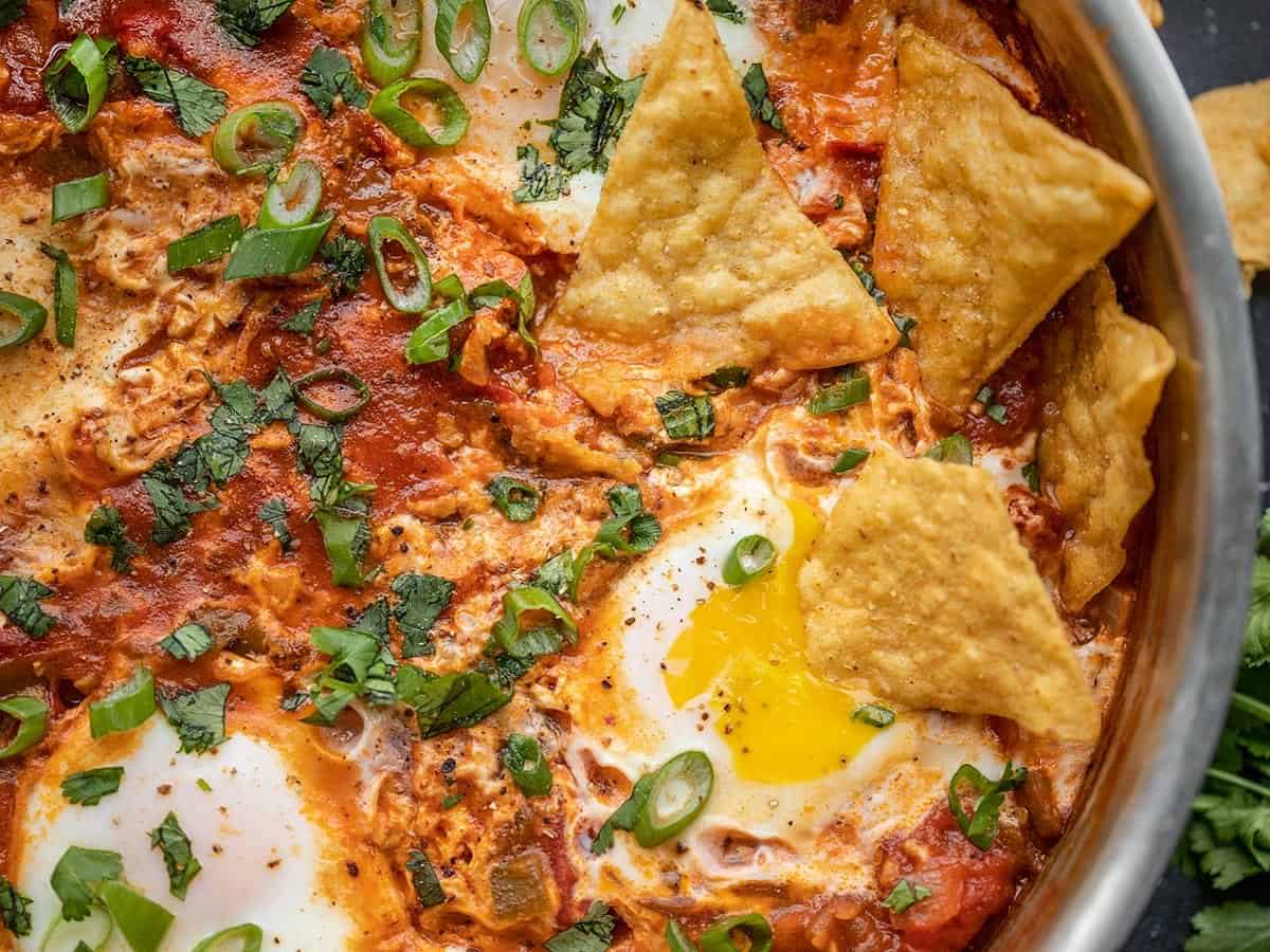 Close up of salsa poached eggs in the skillet with tortilla chips