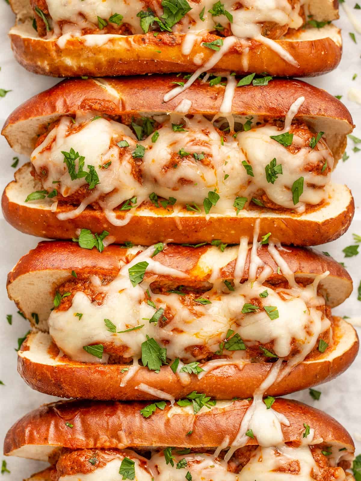 Overhead view of slow cooker meatball subs lined up in a row.