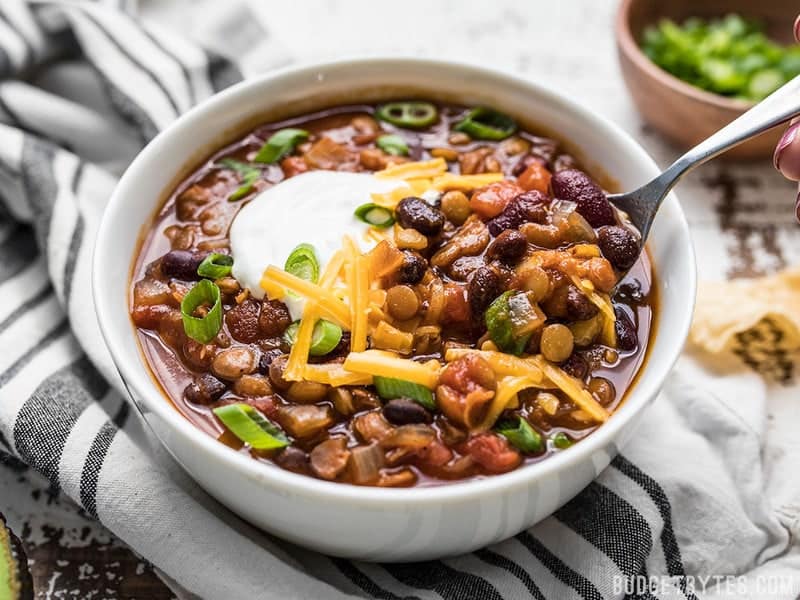 Front view of a bowl of Slow Cooker Vegetarian Lentil Chili with cheese and sour cream on top