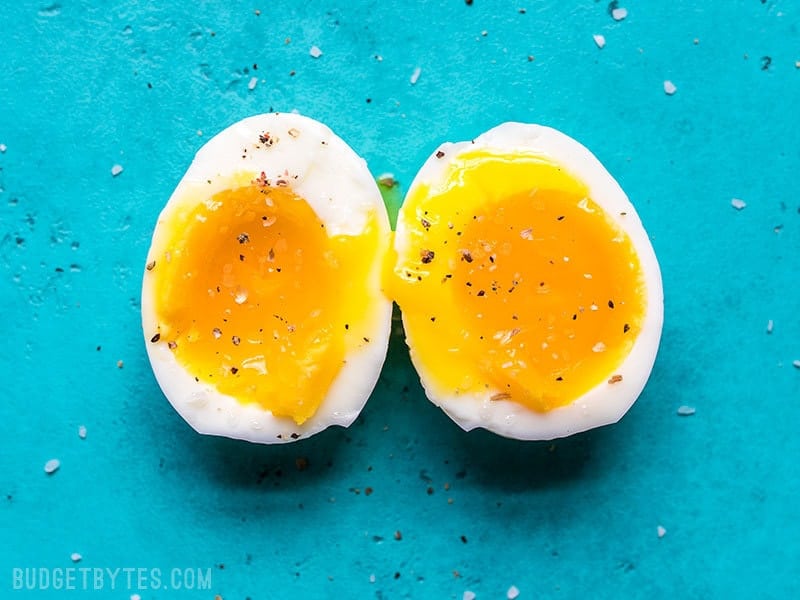 Perfectly cooked soft boiled eggs cut open to reveal the silky yolk.