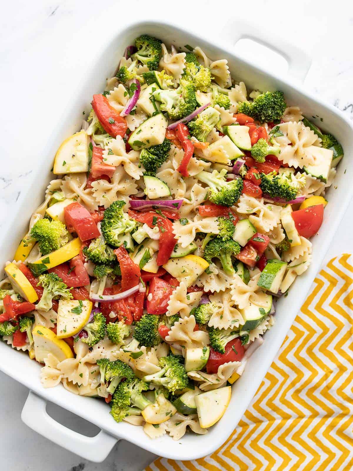 Overhead view of summer vegetable pasta salad in a rectangular casserole dish