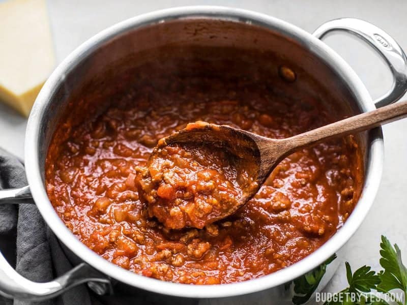 Close up of a spoon scooping The Best Weeknight Pasta Sauce out of the pot