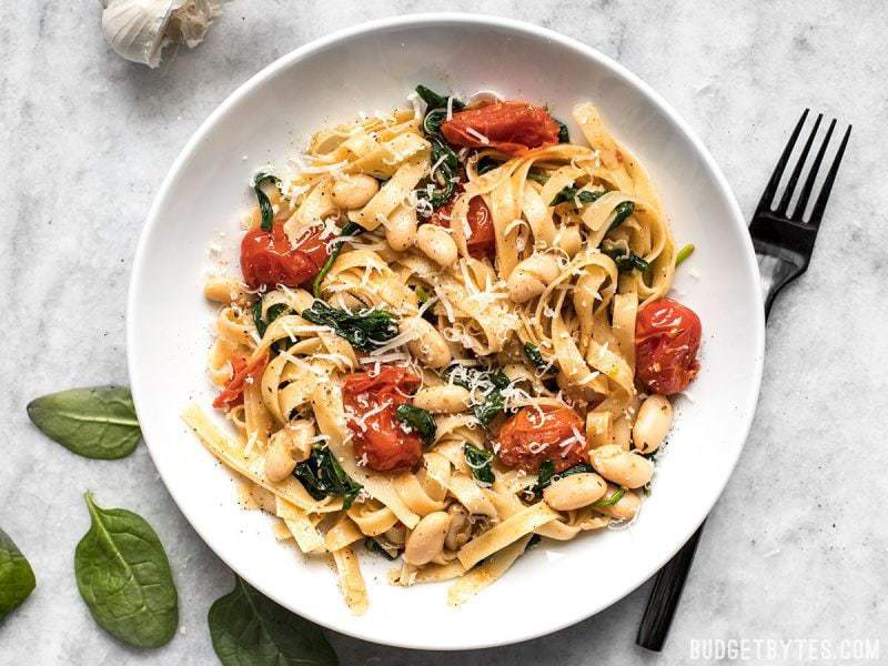 This Tuscan White Bean Pasta is a fast and flavorful dish that is perfect for weeknight dinners. The caramelized garlic, basil, and Parmesan pack a huge flavor punch! BudgetBytes.com