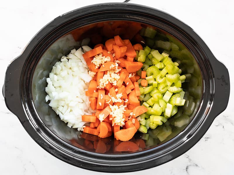 Diced onion, carrot, celery, and minced garlic in the slow cooker